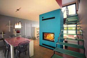 Fondis - Ulys 900 Double Sided - 14.9kW Inset Wood Stove in a blue wall divider between living room and dining area