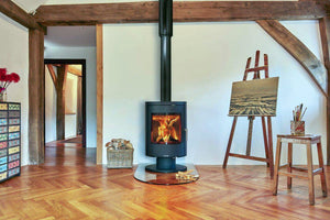 Opus Harmony multi-fuel stove on glass hearth with flames in an art room