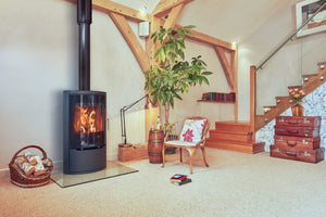 Opus Harmony glass door multifuel stove with glass hearth in a modern cabin living room