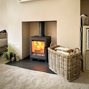 Woodford - Pankhurst Small 4.1kW Eco Design Wood Burning Stove in a white fireplace suite and black hearth